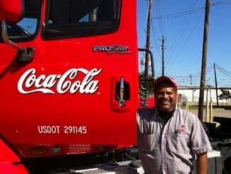 Red Coca-Cola truck and a proud truck driver
