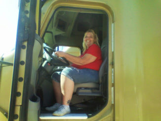 Woman truck driver in yellow truck