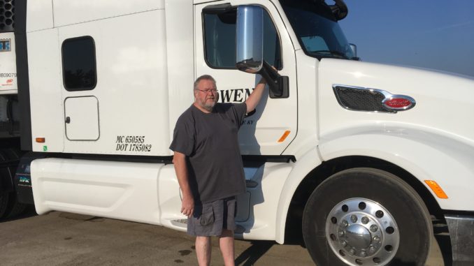 Truck driver with his white semi-truck