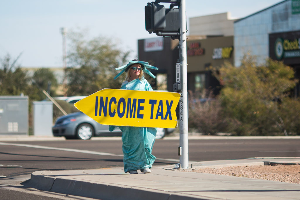 Person holding a yellow arrow pointing to tax center