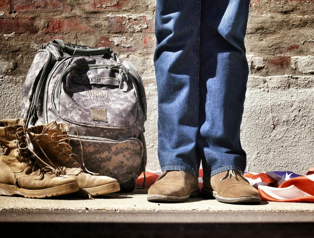 Boots of a man standing with camo bag