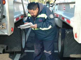 Truck Driver performs pre-trip inspection on his vehicle.