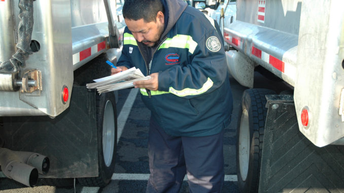 Truck Driver performs pre-trip inspection on his vehicle.
