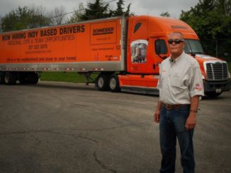 Driver stands next to his tractor-trailer