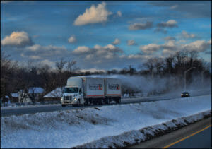Double trailer truck driving through the snow