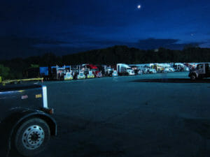 Many trucks lined up at a truck stop at night