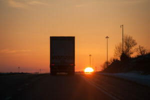 Truck driving into sunset