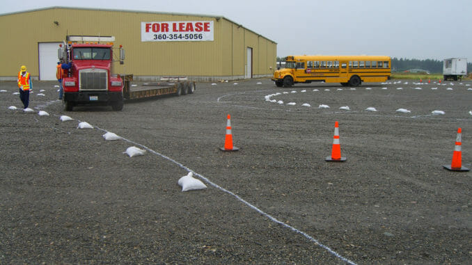 Red truck and school bus on a driving course