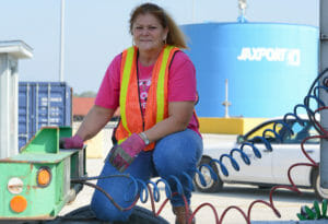 Woman truck driver at work wearing orange vest
