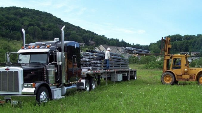 Black flatbed truck loaded in a field