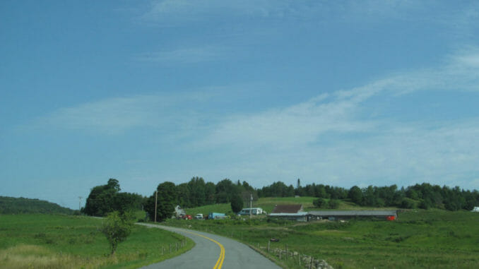 Empty road cutting through fields in Vermont
