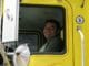 Smiling truck driver in yellow truck
